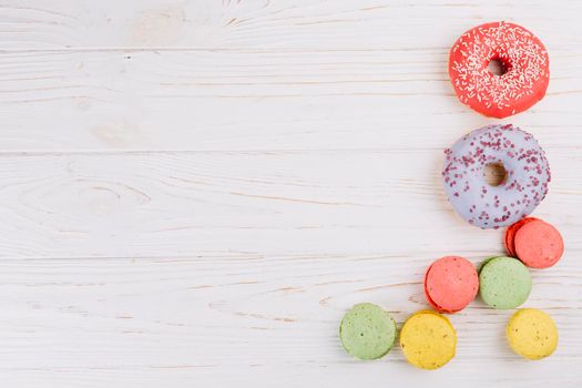 overhead view macaroons donuts wooden texture background. High resolution photo