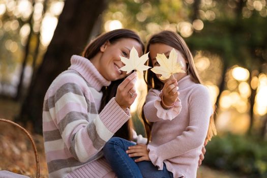 Mother and daughter enjoying autumn in park.