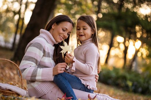 Mother and daughter enjoying autumn in park.