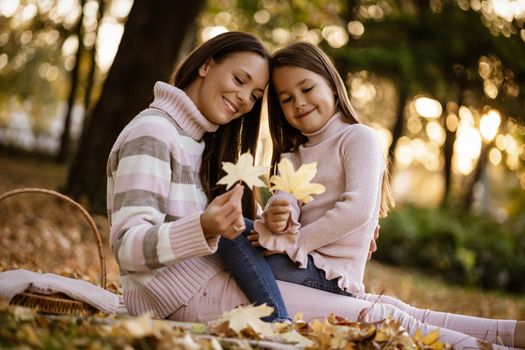 Mother and daughter enjoying autumn in park.