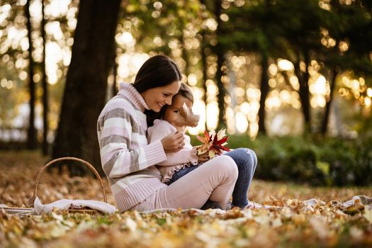 Mother and daughter enjoying autumn in park.