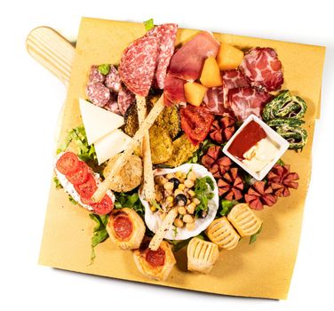 mixed antipasto platter with cold cuts and legumes and cheeses on a white background