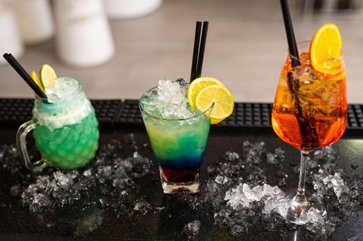 composition of various cocktails on the counter in strong colors and fruit on the head