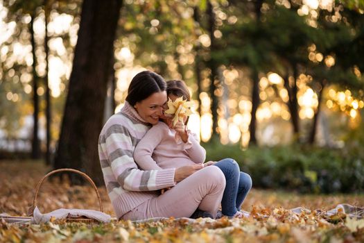 Mother and daughter enjoying autumn in park.