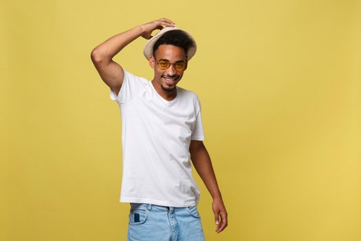 Close up portrait of young afro american shocked tourist , holding his eyewear, wearing tourist outfit, hat, with wide open eyes