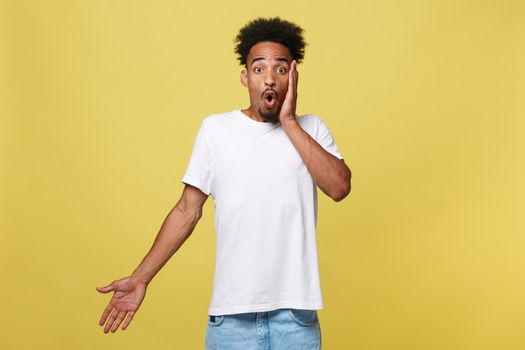 Emotional and People Concept - Portrait of excited young African American man screaming in shock and amazement holding hands on head