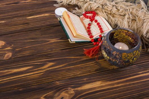 Lighted candle holder; kuran and red prayer beads on wooden desk Picture on pik. Resolution and high quality beautiful photo
