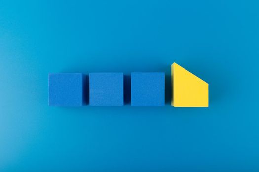Blue toy cubes in a row on dark blue background. Concept of individuality, being different from others, leadership or unique ideas 
