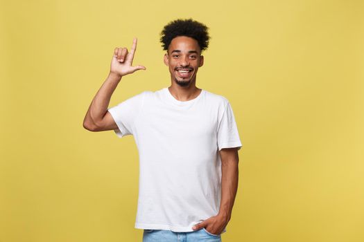 Young handsome african american man over yellow background pointing upwards