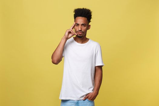 Handsome African-American teenager with casual cloth isolated on yellow background