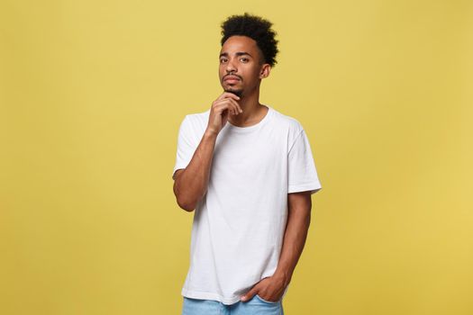 Handsome African-American teenager with casual cloth isolated on yellow background