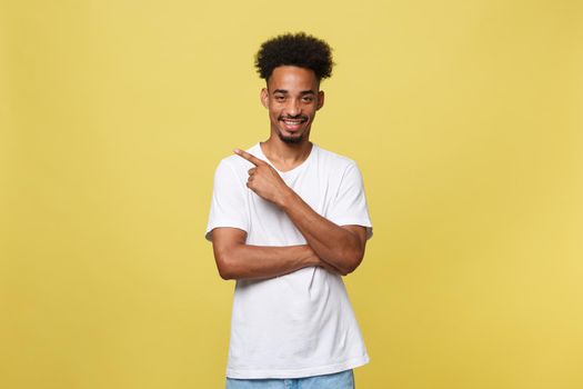 Young handsome african american man over yellow background pointing upwards