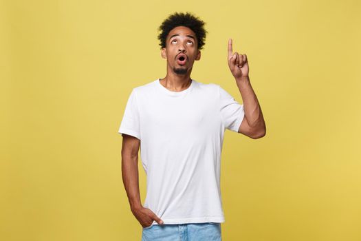 Young handsome african american man over yellow background pointing upwards