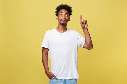 Young handsome african american man over yellow background pointing upwards