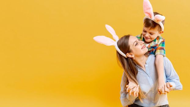 copy space mother son with rabbit ears looking each other. High resolution photo