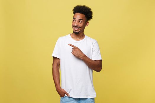 Young handsome african american man over yellow background pointing upwards