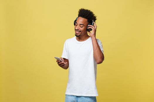 Portrait good-looking african male model with beard listening to music. Isolated over yellow background.