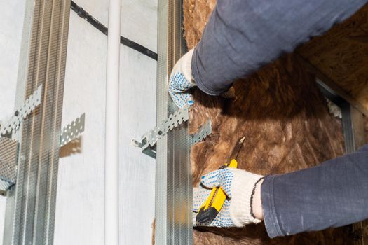 Home renovation A worker attaches mineral wool to the walls for further plasterboard cladding. Heat insulation and sound insulation of housing.