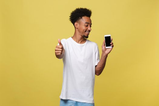 Portrait of cheerful african american man talking on cellphone with thumbs up hand sign.