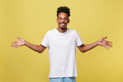 Advertising concept. Portrait of handsome African entrepreneur or office worker wearing suit pointing his finger at yellow studio wall with copy space for your content, looking shocked and surprised