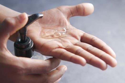 close up of young man hand using sanitizer gel for preventing virus.