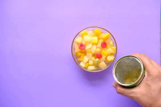 Open can of fruit cocktail on table