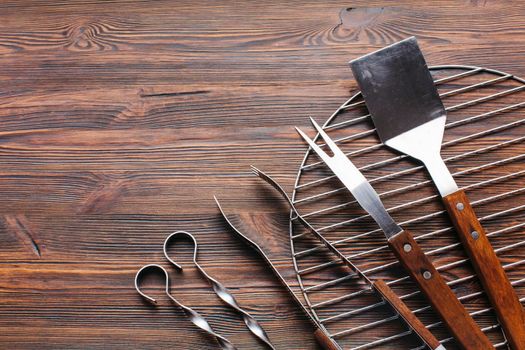 new metallic barbecue utensils wooden background. Beautiful photo