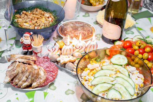 New Year festive table with dinner and candles on the eve of the celebration in Russia
