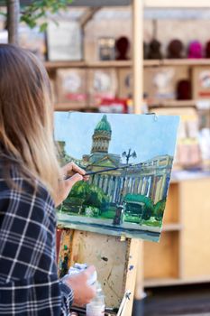 Saint Petersburg, Russia - February 10, 2021: An unknown artist paints the Kazan Cathedral on a street in St. Petersburg