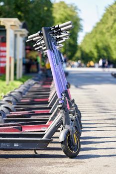 Saint Petersburg, Russia - August 08, 2021: Rental electric scooters in a shared parking lot in the city park in Petersburg