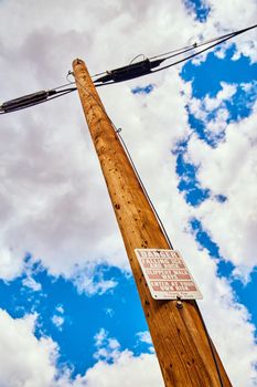 Image of Vertical telephone pole with danger sign of falling ice and rock