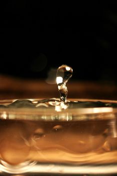 Image of Water splashes in a glass on a brown amber background