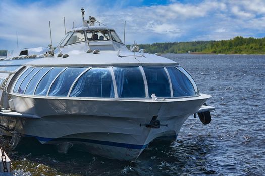 A hydrofoil ship sails along the river. River ship Meteor.