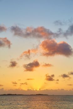Image of Sunrise in tropics with golden sky and pink clouds
