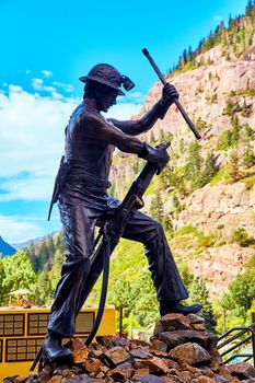 Image of Statue of miner with background of mountains