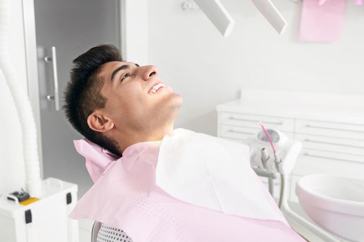 Portrait of happy patient in dental chair. High quality photo
