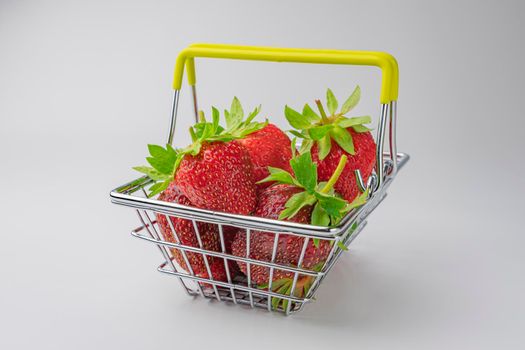 strawberries in a supermarket basket close-up on a white background. High quality photo