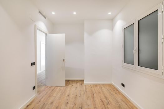 Empty room with window and hardwood floor after renovation. Modern style new interior