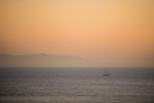 Dramatic seascape of Catalina Island from afar with ship and mountains in the distance