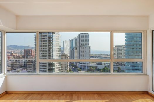 Sunny living room in the morning with panoramic view to the district with modern buildings