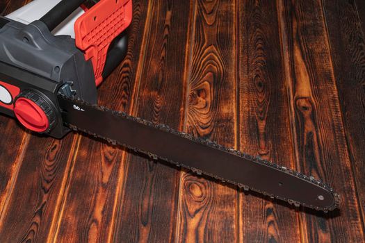 Electric chain saw on wood on a wooden background. Top view. High quality photo