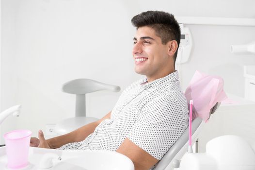 Portrait of happy patient in dental chair. High quality photo