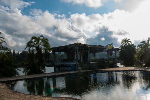 Guatape, Colombia - December 12, 2017: Pablo Escobar's old estate La Manuela in ruin with palm trees and reflection pool