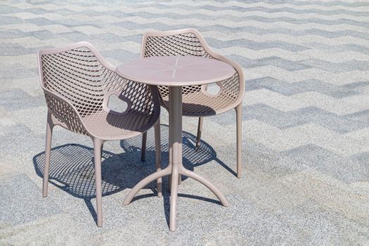 table and chairs on the tile of an outdoor cafe. High quality photo