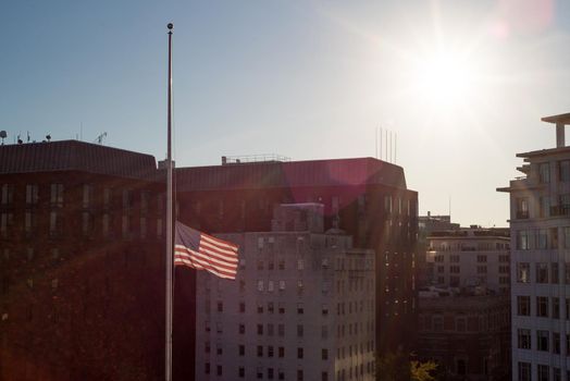 US flag flying at half mast during sunset in Washington DC horizontal