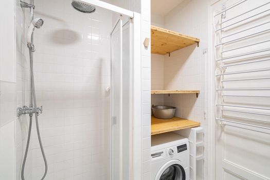 Small bathroom interior with shower and washing machine.