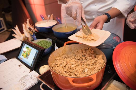 Serving pulled chicken onto small plate.