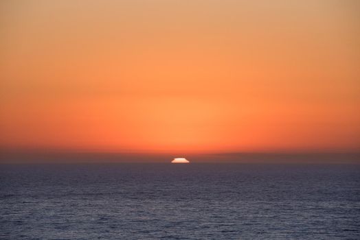 California sunset over the ocean horizon with bright orange sky Los Angeles