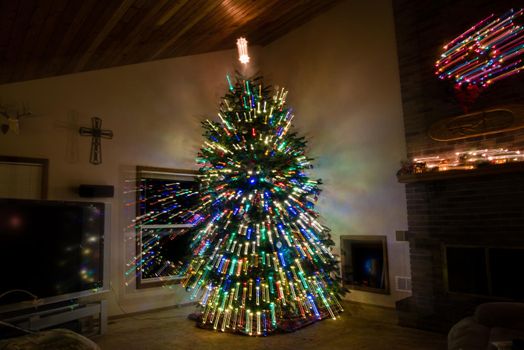 Large decorated Christmas tree inside of living room with light streaks