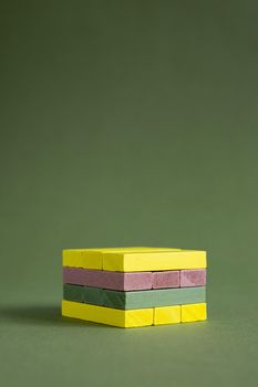 Jenga wood colourful green and yellow on green background copy space, platform for product copy space